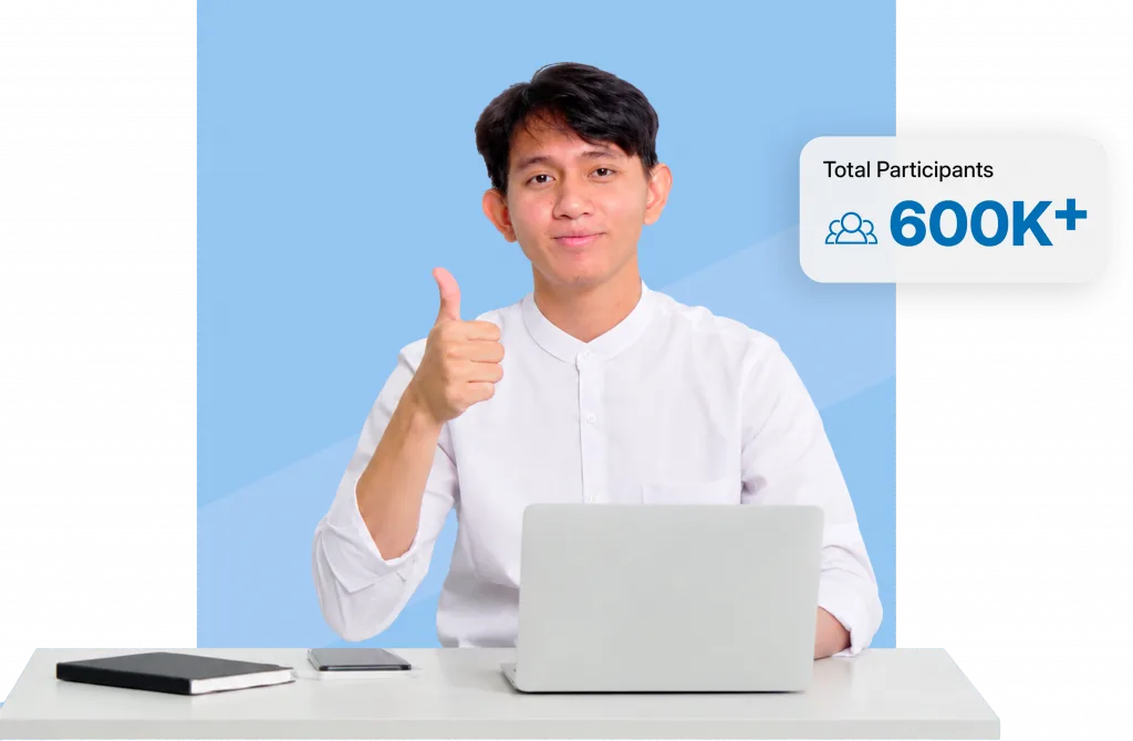 Man in a white shirt gives a thumbs up while seated at a laptop; blue backdrop and a 'Total Participants 600K+' badge appear on the right.”,